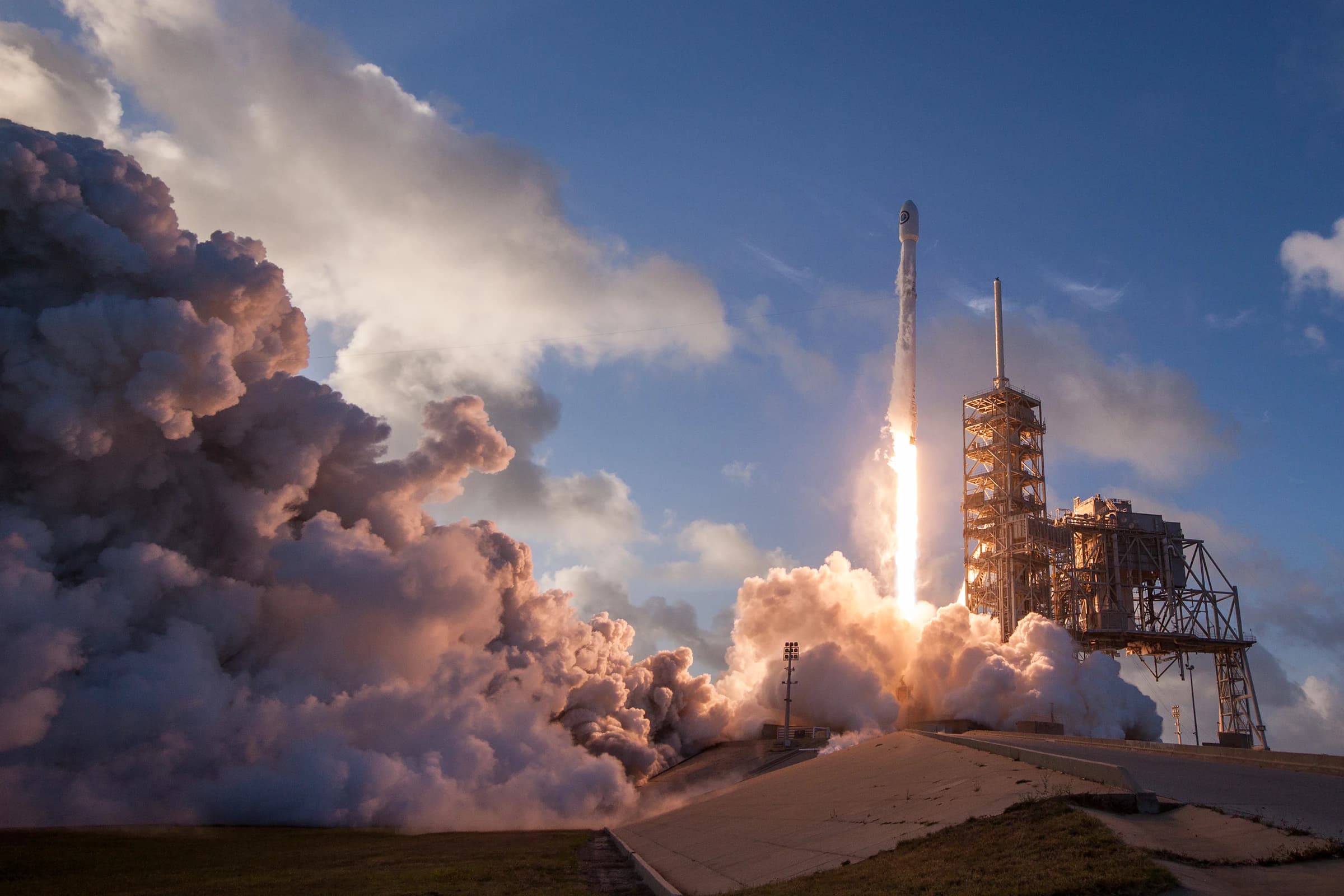 A launch vehicle climbing away from the pad through its own exhaust plume