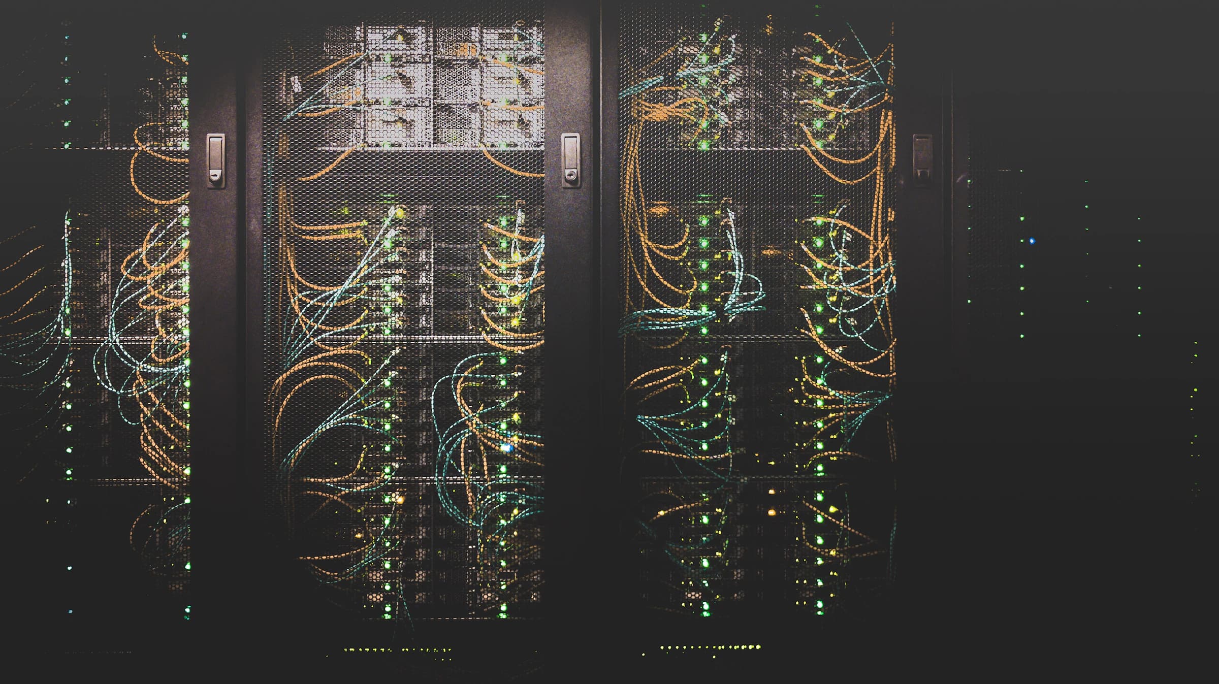 Rows of server racks in a compute hall with bundled network cabling