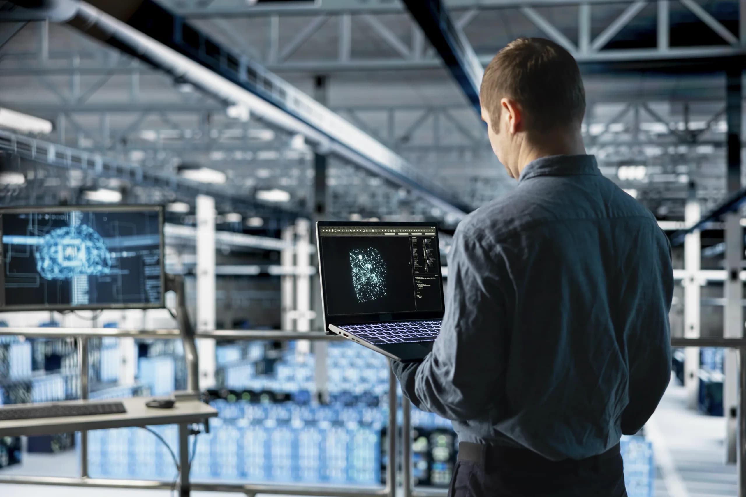 An IT specialist in a data centre watching a large screen that visualises an AI language model