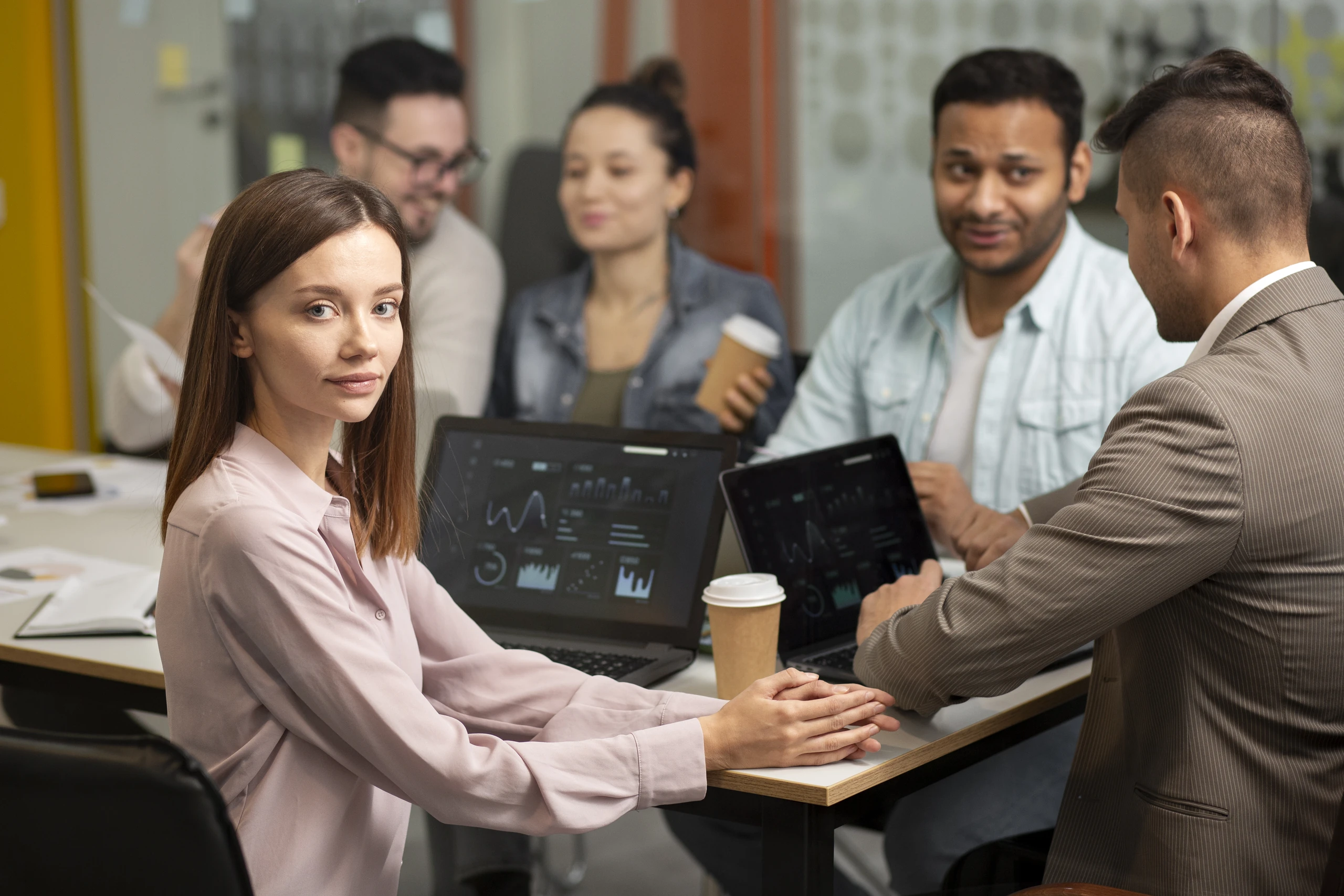 Team reviewing workforce analytics dashboards on laptops in a meeting